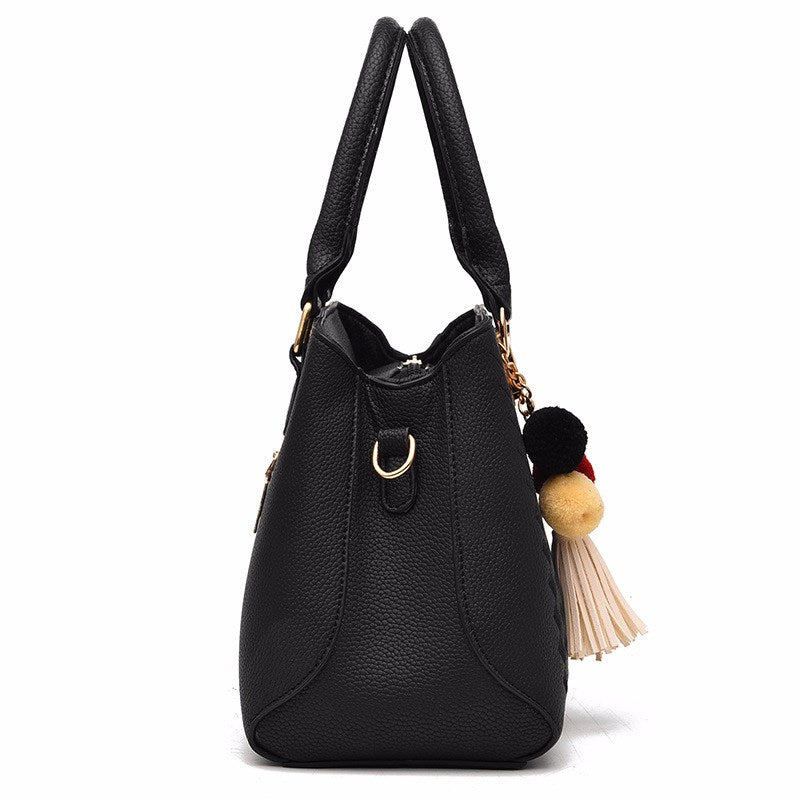 Embossed top handle handbag with pompom