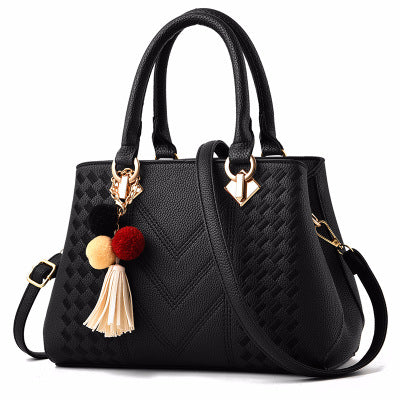 Poppy | Embossed handbag with pompom charm and strap