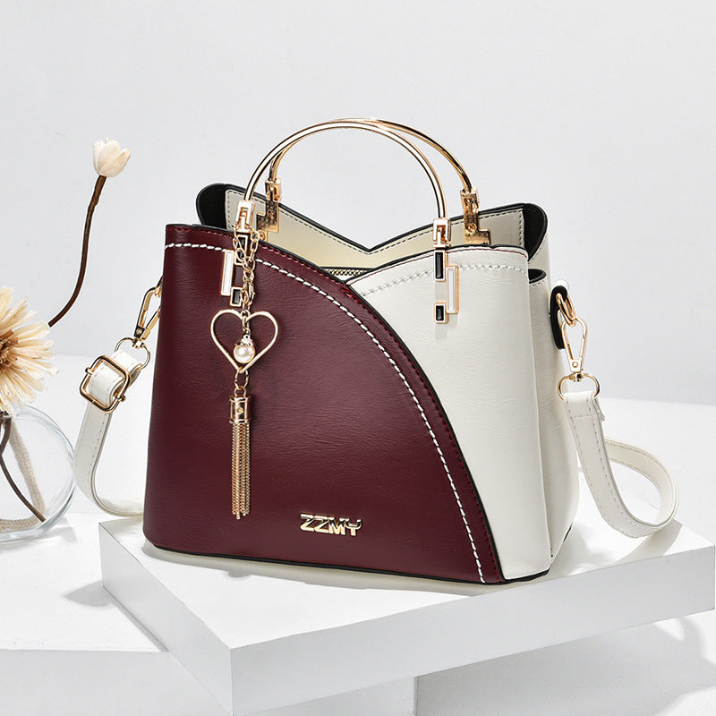 Colour block handbag with heart tassel