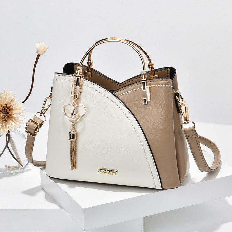 Colour block handbag with heart tassel