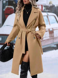 Woman in long belted double-breasted coat